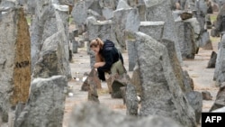 A young girl lights a candle in front of a monument at the Treblinka World War II-era Nazi death camp in Poland on October 2.