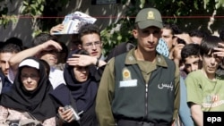 Iranian troops stand guard as locals gather to watch a public execution in the capital, Tehran.